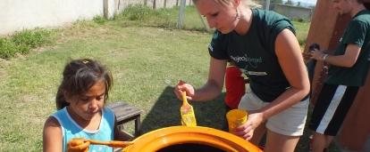 A Projects Abroad volunteer paints with children in Argentina on our project for teenagers A volunteer painting tyres with children in Argentina on our project for high school students